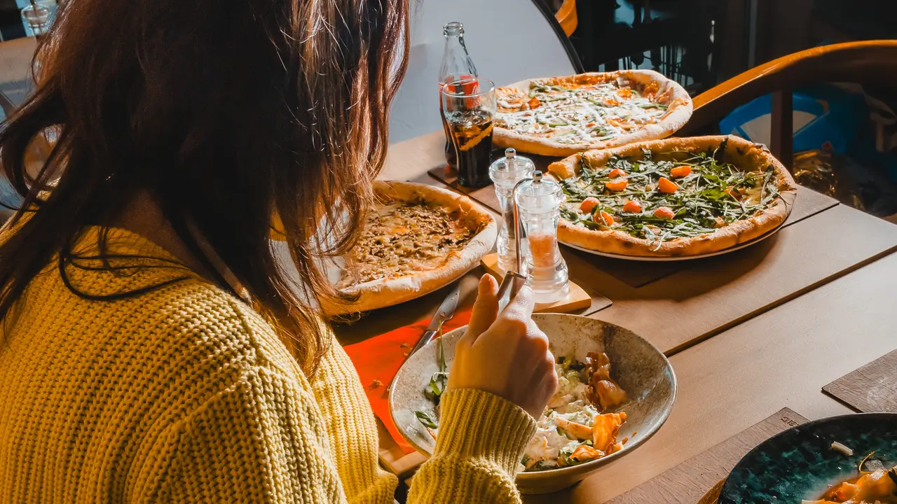 Pizza and pasta at a table in Mia